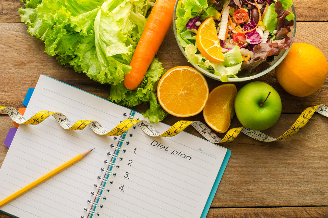Ernährungsplan-Tagebuch und gesunde Lebensmittel auf dem Tisch