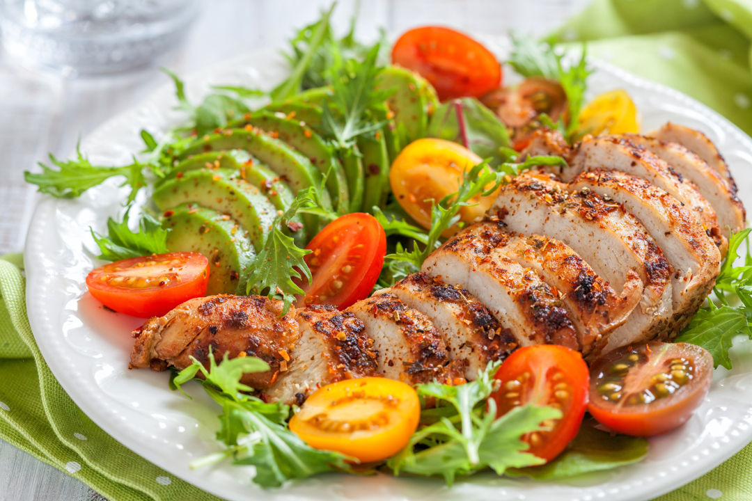 Low Carb Mahlzeit: Teller mit gebratener Putenbrust und Gemüse mit Salat als Beilage