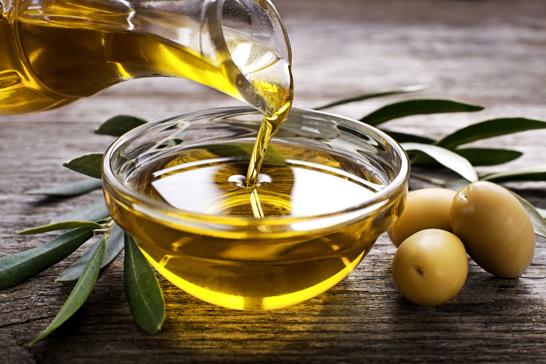 Schälchen, welches mit Olivenöl gefüllt wird. Daneben ein Olivenzweig mit 3 Oliven